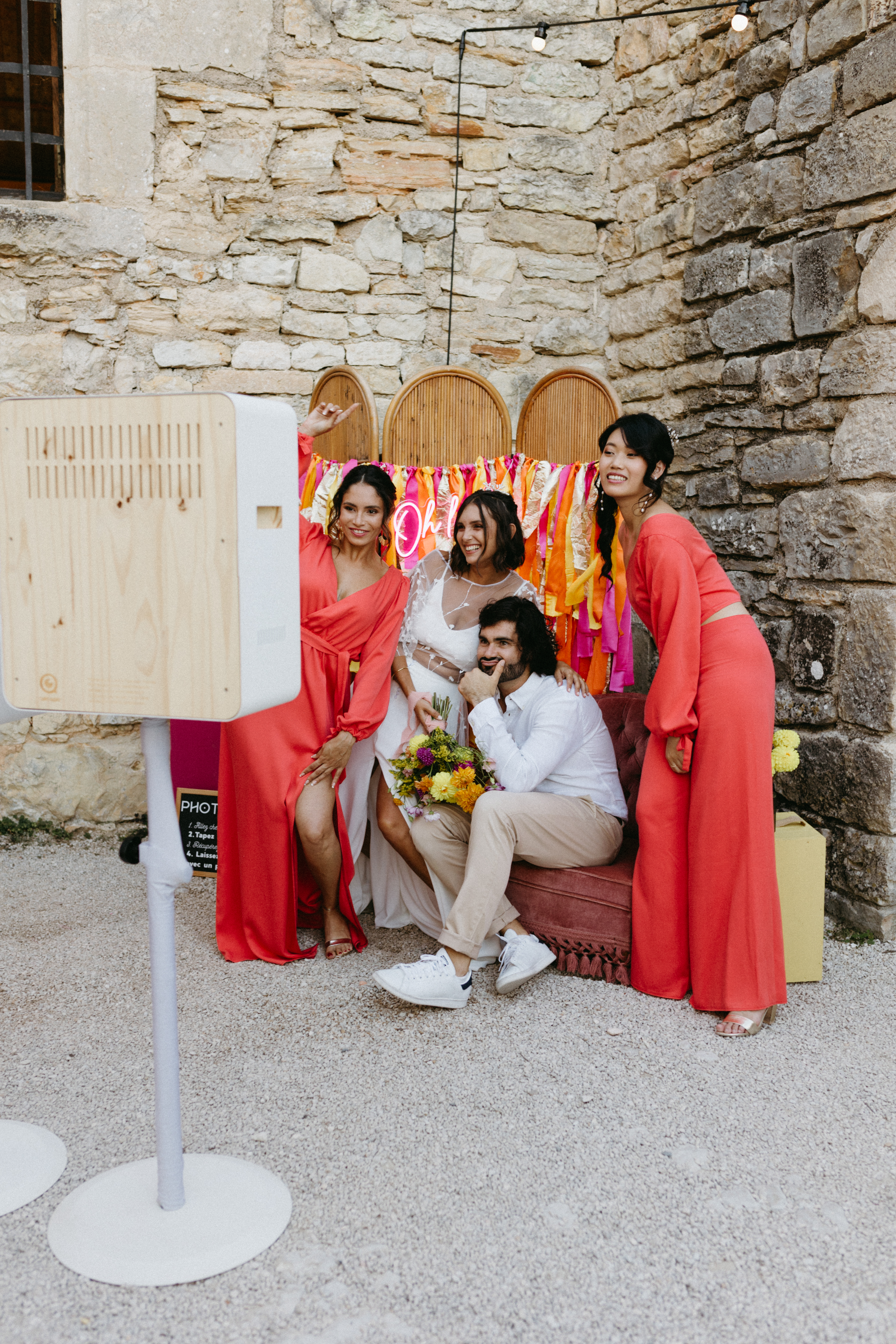 Des mariés posent devant un Photobooth