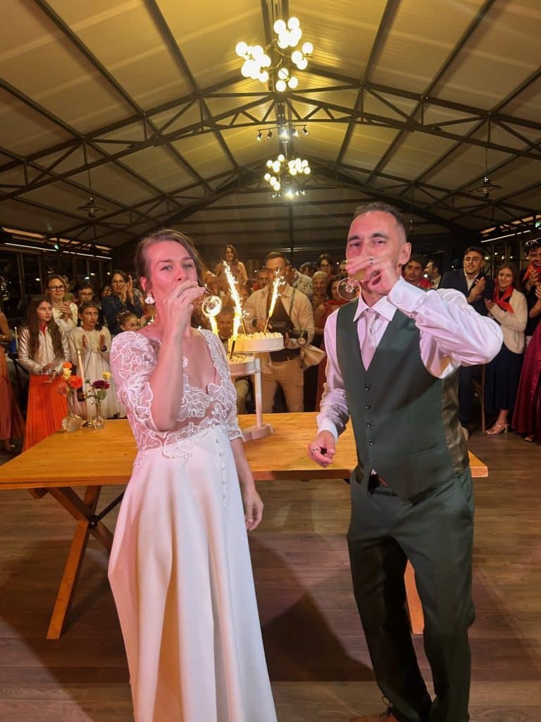 Les mariés devant le gâteau et les feux de bengale
